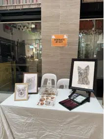 Portraits by Izzy stall displaying pet portrait artwork.